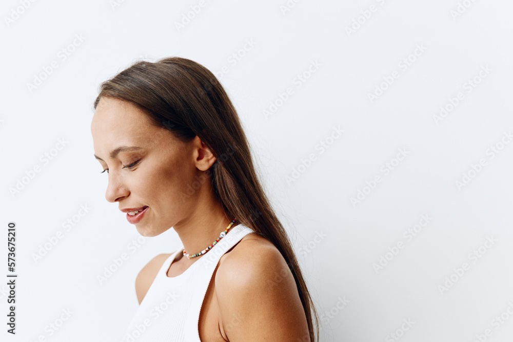 Portrait of a young beautiful woman with tanned skin model on a white background in a white T-shirt with a chain around her neck with a beautiful smile Portrait of a young beautiful woman with tanned skin model on a white background in a white T-shirt with a chain around her neck with a beautiful smile