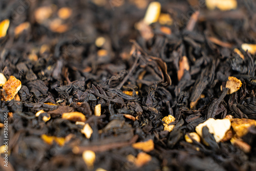Black tea with orange peel and cinnamon close-up top view