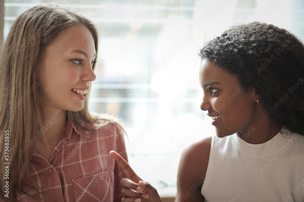 two young women talking to each other two young women talking to each other