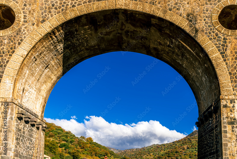 bridge with big arc and columns it traditional italian vintage style of architecture with background of nature with green garneds and blue sky , european old concept landscape
