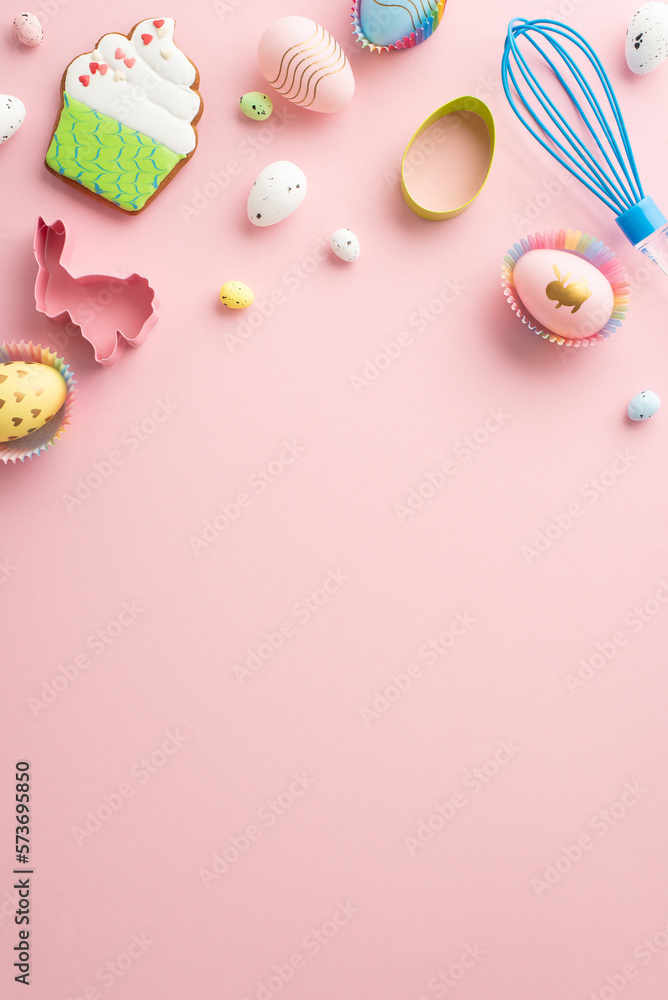 Easter concept. Top view vertical photo of whisk colorful easter eggs in paper baking molds and cupcake shaped gingerbread on isolated pastel pink background with empty space Easter concept. Top view vertical photo of whisk colorful easter eggs in paper baking molds and cupcake shaped gingerbread on isolated pastel pink background with empty space