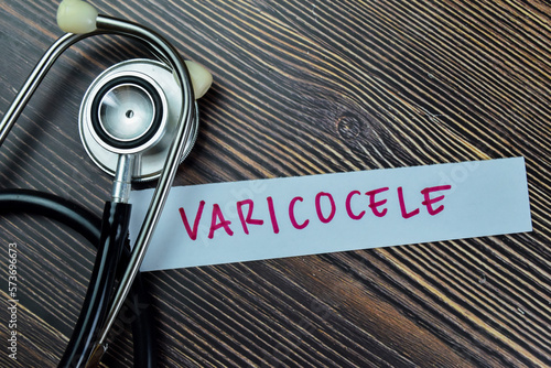 Concept of Varicocele write on sticky notes with stethoscope isolated on Wooden Table. photo