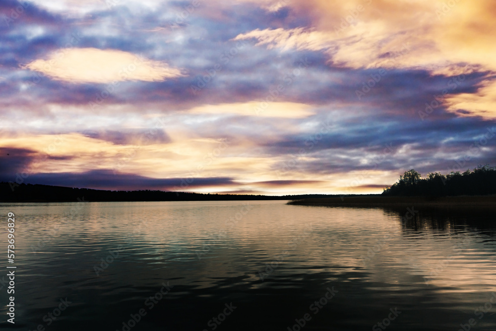 Dark lake landscape. Stormy weather scenic view. Melancholic landscape. Rainy day by the lake. Sad panoramic background. Calm sunset by the lake. Vibrant color sky.