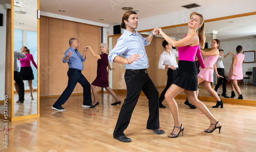 Fototapeta Naklejka Na Ścianę i Meble -  Couple of dancers rehearsing ballroom dances in dance studio