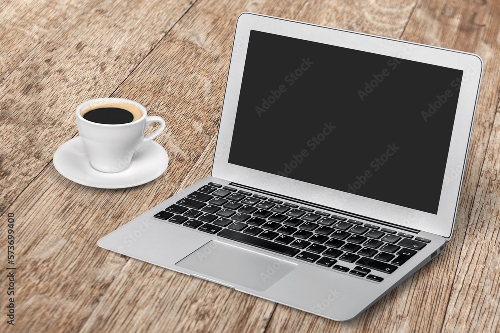 Open laptop computer on desk and cup of coffee Open laptop computer on desk and cup of coffee