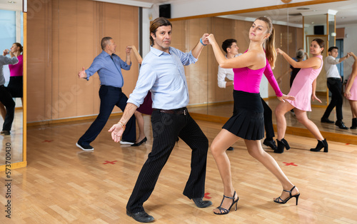 girl choreographer shows group of dancers movements of modern energetic dance