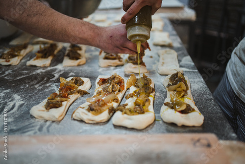 Shot of raw vegetable stuffed bread sticks getting ready. They are putting olive oil on them.