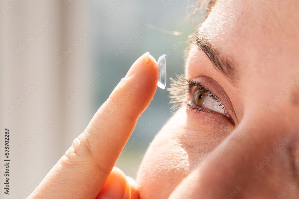 Close-up portrait caucasian woman putting on a contact lens. Close-up portrait caucasian woman putting on a contact lens.