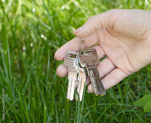 female hand holds the keys. A bunch of keys found in the grass. The concept of lost keys that were found. High quality photo