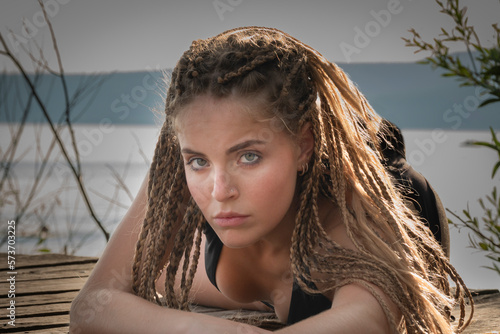 Ragazza bionda che prende il sole sul lago photo