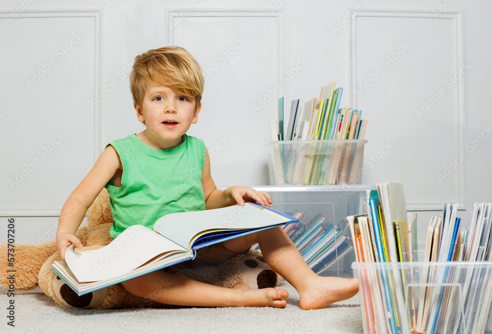 Portrait of blond boy immersed in text, surrounded by books Portrait of blond boy immersed in text, surrounded by books