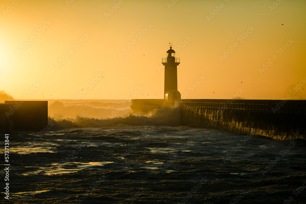 Lighthouse during golden sunset at Atlantic ocean, Porto, Portugal.