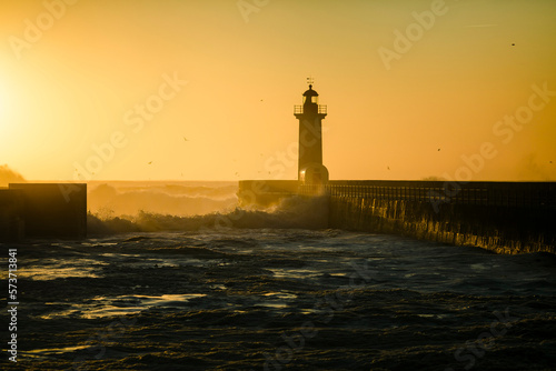 Lighthouse during golden sunset at Atlantic ocean, Porto, Portugal.