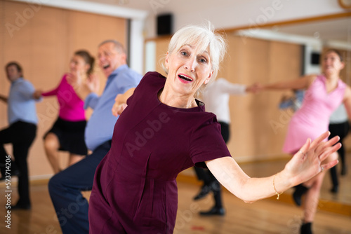 elderly lady with man dancing a jive in ballroom dance class