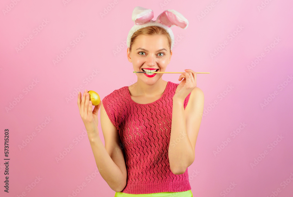 Happy Easter. Smiling girl in bunny ears painting egg for Easter holiday. Easter egg ideas. Bunny woman in rabbit ears with painted egg. Bunny woman coloring eggs for Easter. Egg hunt. Happy Easter. Smiling girl in bunny ears painting egg for Easter holiday. Easter egg ideas. Bunny woman in rabbit ears with painted egg. Bunny woman coloring eggs for Easter. Egg hunt.