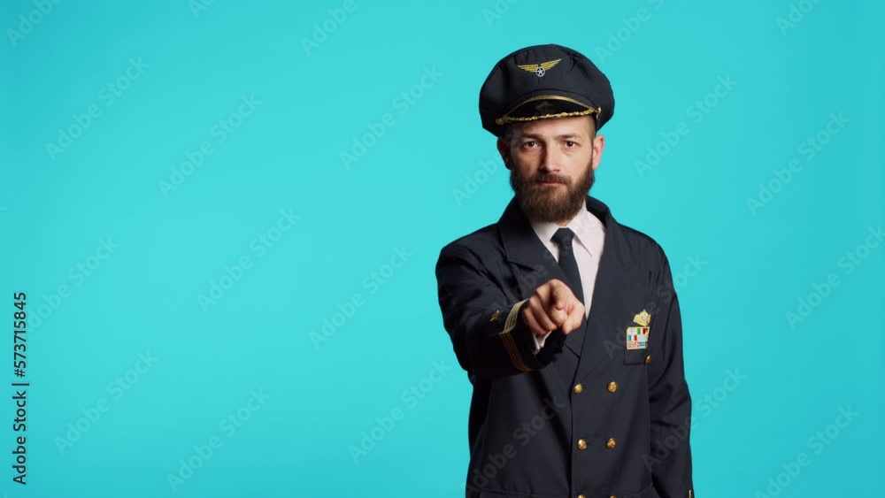 Airplane pilot in uniform pointing at camera and choosing, saying i want you for commercial flights cabin aircrew. Young male captain flying plane and acting positive, feeling confident. Airplane pilot in uniform pointing at camera and choosing, saying i want you for commercial flights cabin aircrew. Young male captain flying plane and acting positive, feeling confident.