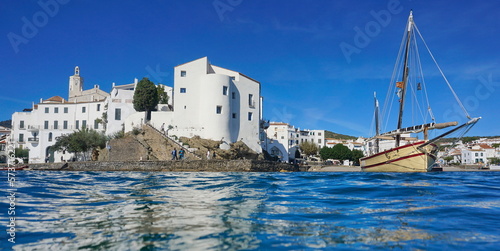 Spain coastal Mediterranean village of Cadaques with a traditional boat seen from sea surface, Costa Brava, Catalonia