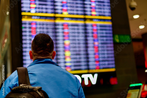 Photos Passenger checks his flight in front of the arrivals and departures screen at El