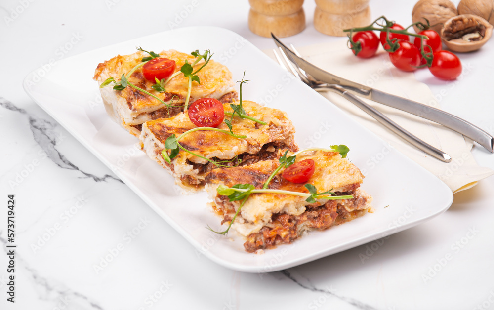 Lasagna cut into portions served on a white dish