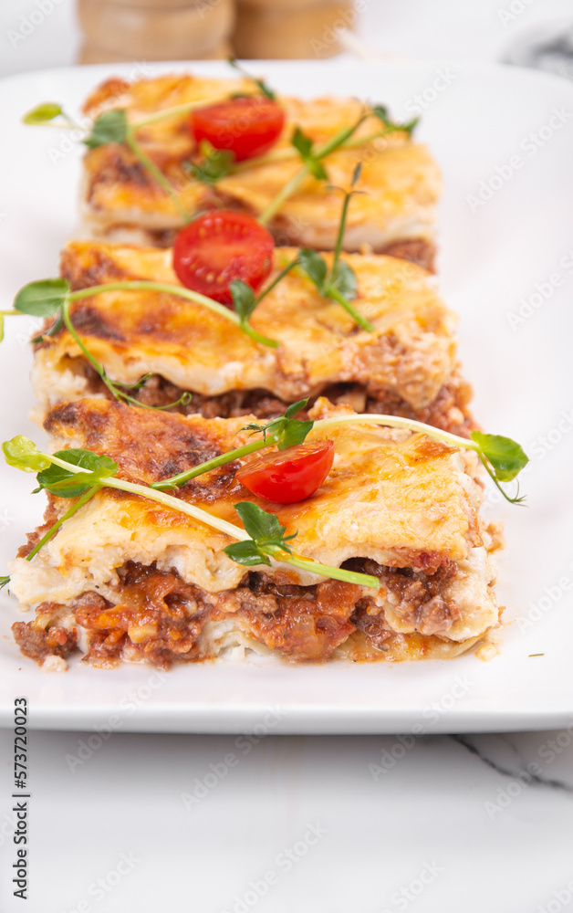 Lasagna cut into portions served on a white dish