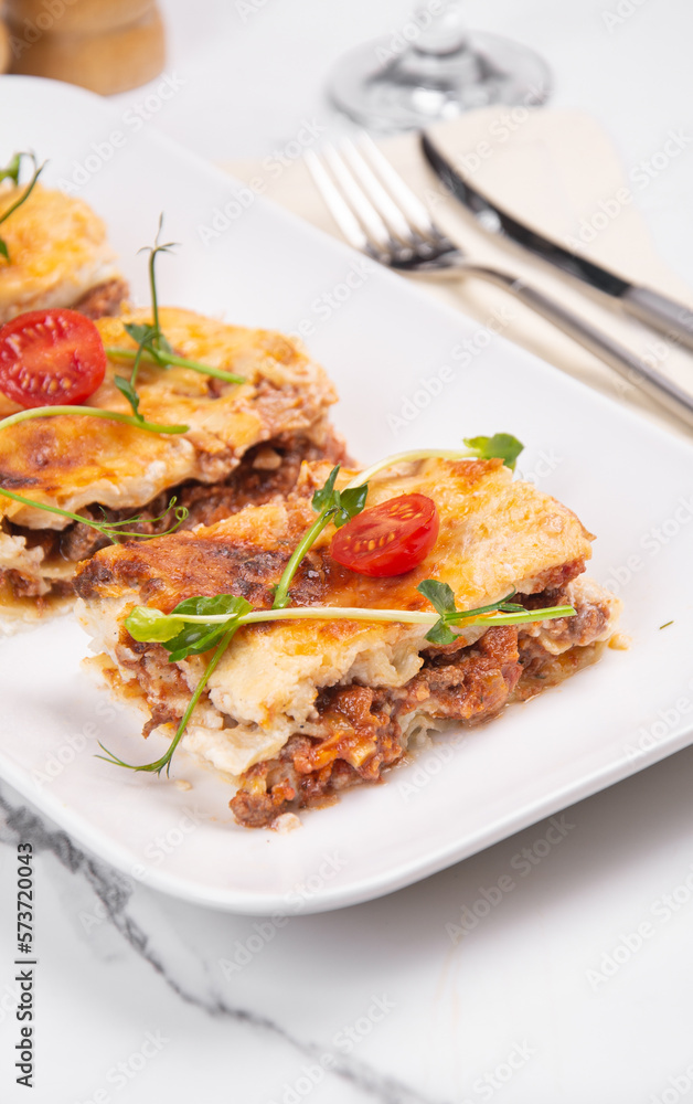 Sliced lasagna on a white platter Sliced lasagna on a white platter
