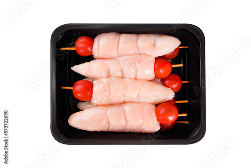 Raw chicken skewers.Raw chicken inner on skewers with tomatoes in a tray on a white background.Close-up.Top view. photo