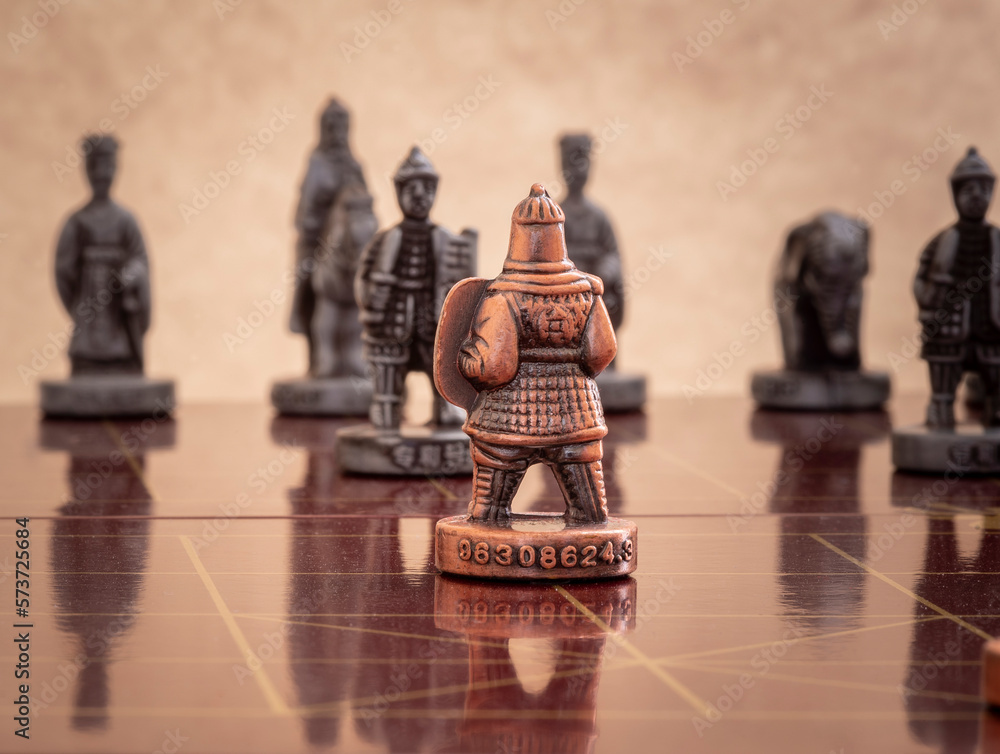 Fototapeta premium Chinese chess bronze pawn faces opponent.