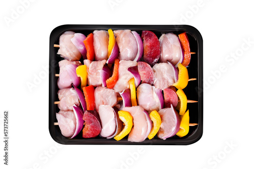 Raw uncooked Chicken meat, kebab on skewers.Raw chicken leg meat skewers with vegetables, plums, peppers, onions, in a tray on a white background.Top view.Close-up. photo