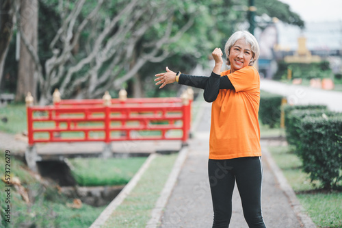 white-haired elderly person exercising in the park early in the morning.