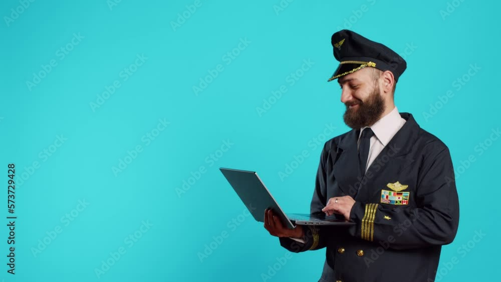 Modern aircrew captain using laptop on camera, browsing online website and social media app. Male pilot working on commercial flights and holding wireless computer, navigating internet. Modern aircrew captain using laptop on camera, browsing online website and social media app. Male pilot working on commercial flights and holding wireless computer, navigating internet.