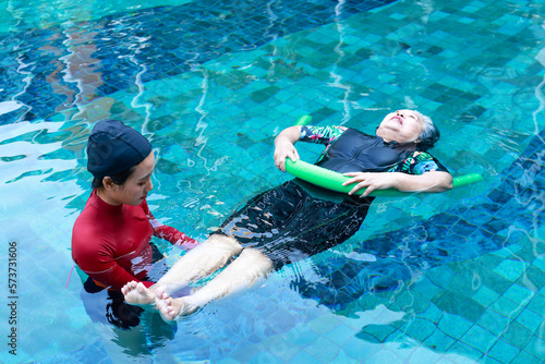 Asian woman or physiotherapist helping elderly female patient with hydrotherapy It is a rehabilitation and exercise in the water. physical therapy center