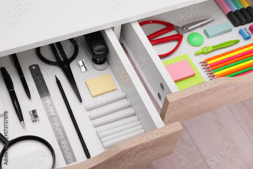 Office supplies in open desk drawers, above view
