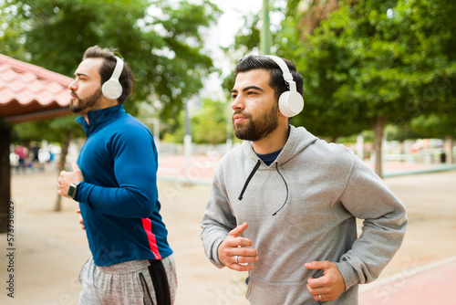 Fototapeta Naklejka Na Ścianę i Meble -  Attractive men running or jogging listening to music