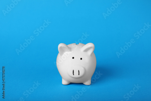 Ceramic piggy bank on light blue background. Financial savings