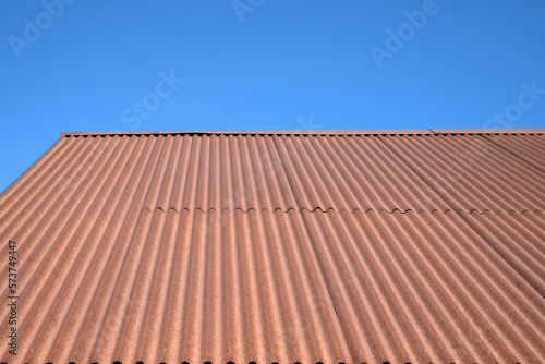 An old rusty metal roof on a blue sky