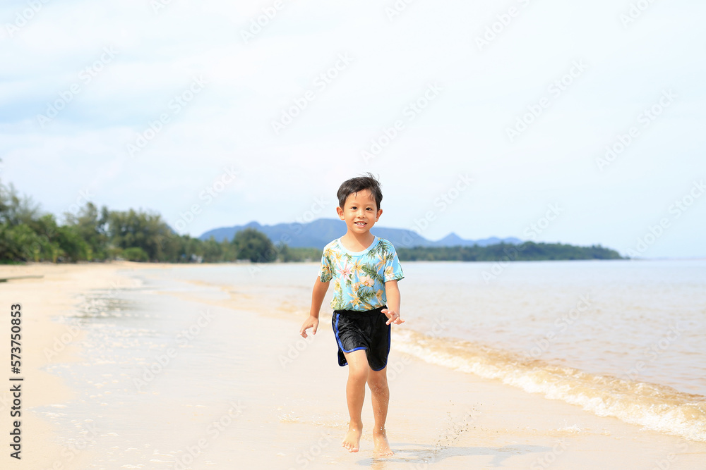 Asian little boy having fun running on tropical sand beach. Asian little boy having fun running on tropical sand beach.