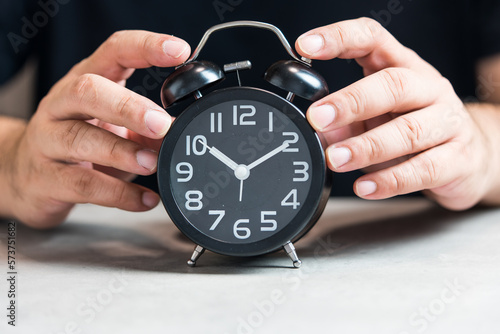 Wallpaper Mural Hand of man holding black alarm clock. The concept of time to reminder. Time concept Torontodigital.ca