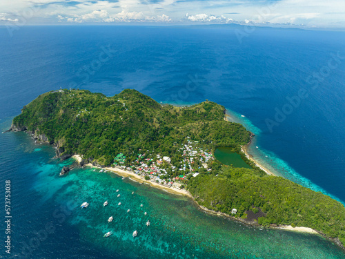 Aerial view of tropical island with a beach. Apo Island. Popular dive site and snorkeling destination with tourists. Negros, Philippines. © Alex Traveler