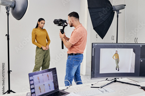 Photography, shooting and photographer with woman fashion model in studio for creative, advertising and image. Media, backstage and profession man videographer with girl and equipment for photoshoot photo