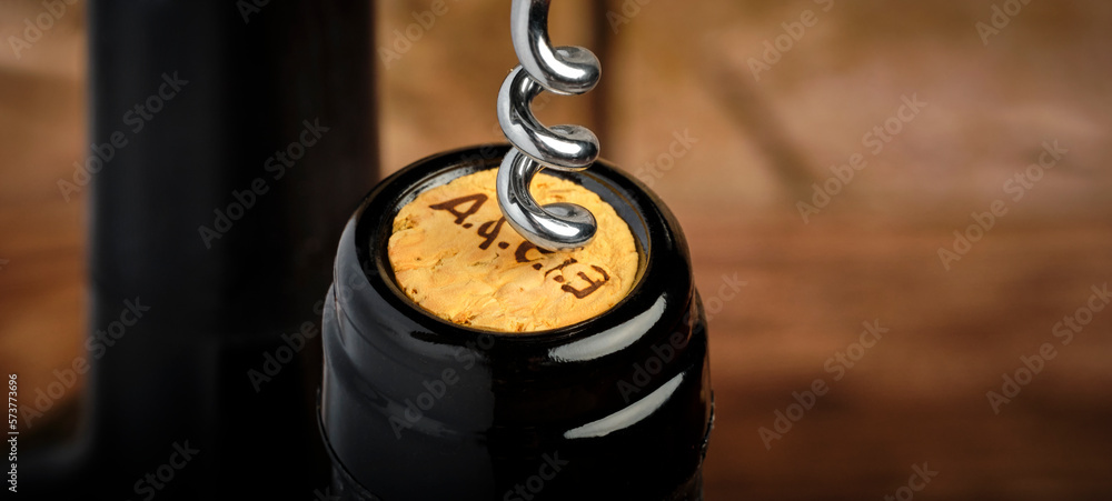 uncorking a bottle of red wine with a classic corkscrew, close-up, copy space uncorking a bottle of red wine with a classic corkscrew, close-up, copy space