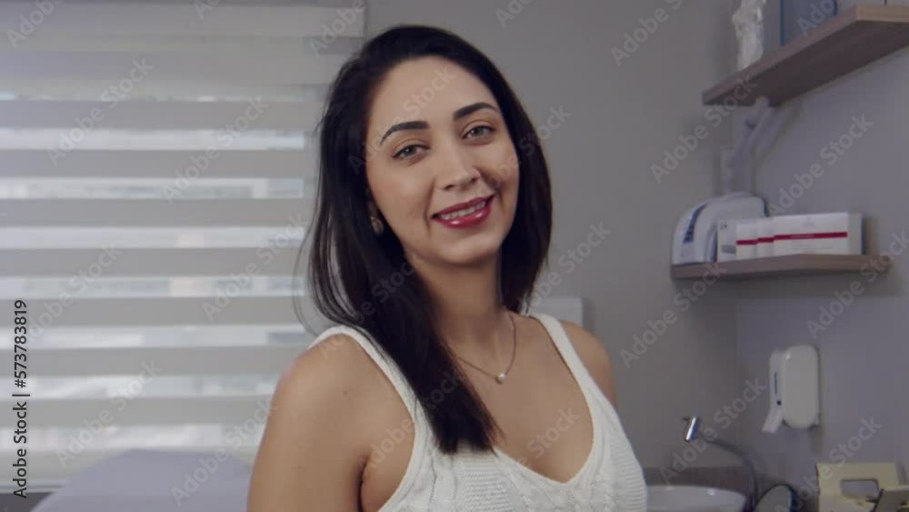 Young Hispanic woman in a doctor's office smiles Young Hispanic woman in a doctor's office smiles