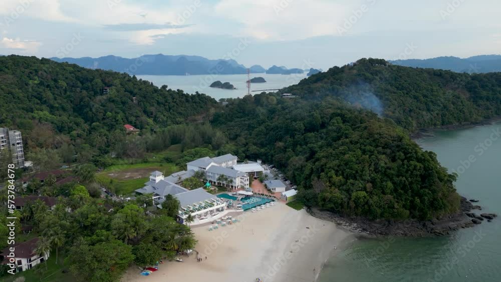 Flying a drone over the beach on Langkawi Island. Buildings and a resort are visible by the beach. Malaysia. Flying a drone over the beach on Langkawi Island. Buildings and a resort are visible by the beach. Malaysia.