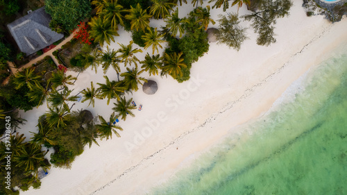This drone shot of Zanzibar's beach is a tropical paradise with palm trees, white sand, and crystal-clear waters.