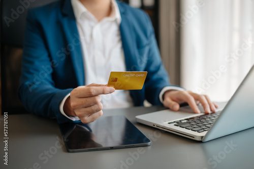 Man using smart phone for mobile payments online shopping,omni channel,sitting on table,virtual icons graphics interface screen