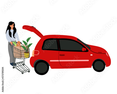 a woman standing at the rear trunk of her car in the parking lot of a supermarket with vegetable products in a box puts them in the car