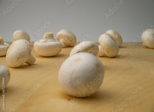 Fresh champignon mushrooms on wooden table  closeup. Mushrooms are like vegetable protein. The concept of vegetarian and vegan food and diet. Veganism and vegetarianism. Cooking at home.