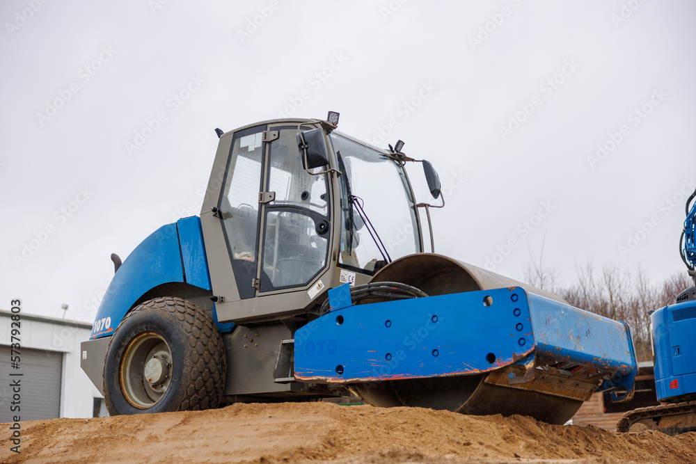 Gravel is compacted with a bulldozer at a construction site