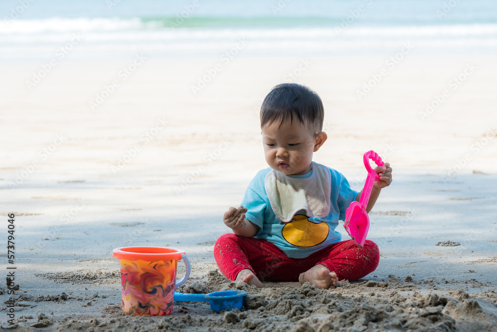 Baby boy playing in sand on a tropical beach Baby boy playing in sand on a tropical beach