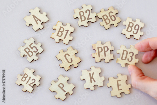 Set of puzzles with 13 essential vitamins with inscriptions on a beige background. Complex A, B1-B12, C, D3, E, K, P, PP.