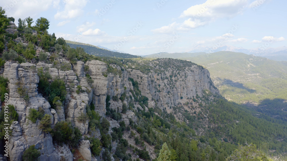Aerial drone view to green mountain valley on a summer day. Beautiful unique shape of mountain with rock formations. Aerial drone view to green mountain valley on a summer day. Beautiful unique shape of mountain with rock formations.